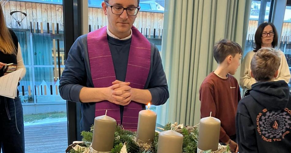 Bild zeigt Pfarrer mit Adventkranz